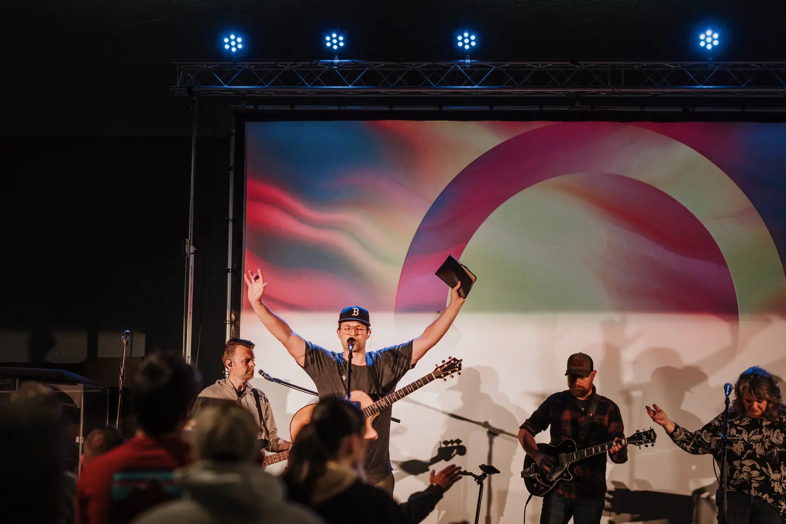 A musical group performs on a stage before an audience.