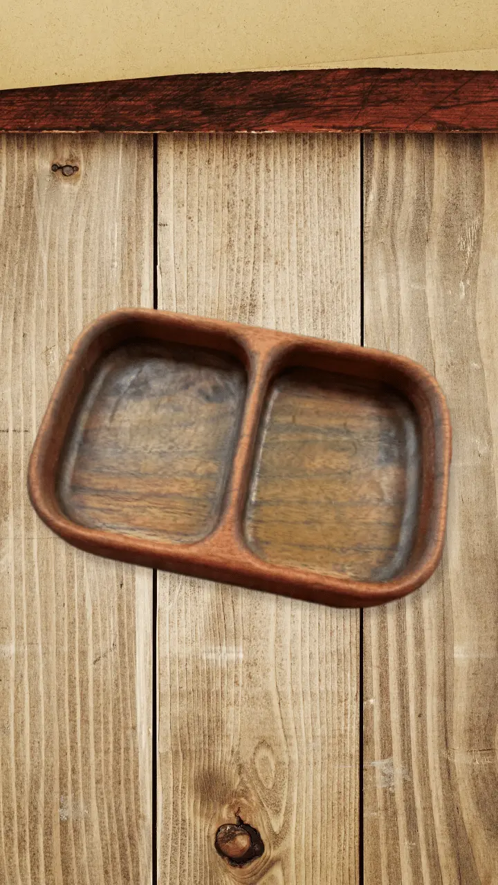 A wooden divided serving tray sits on a rustic wooden plank surface.