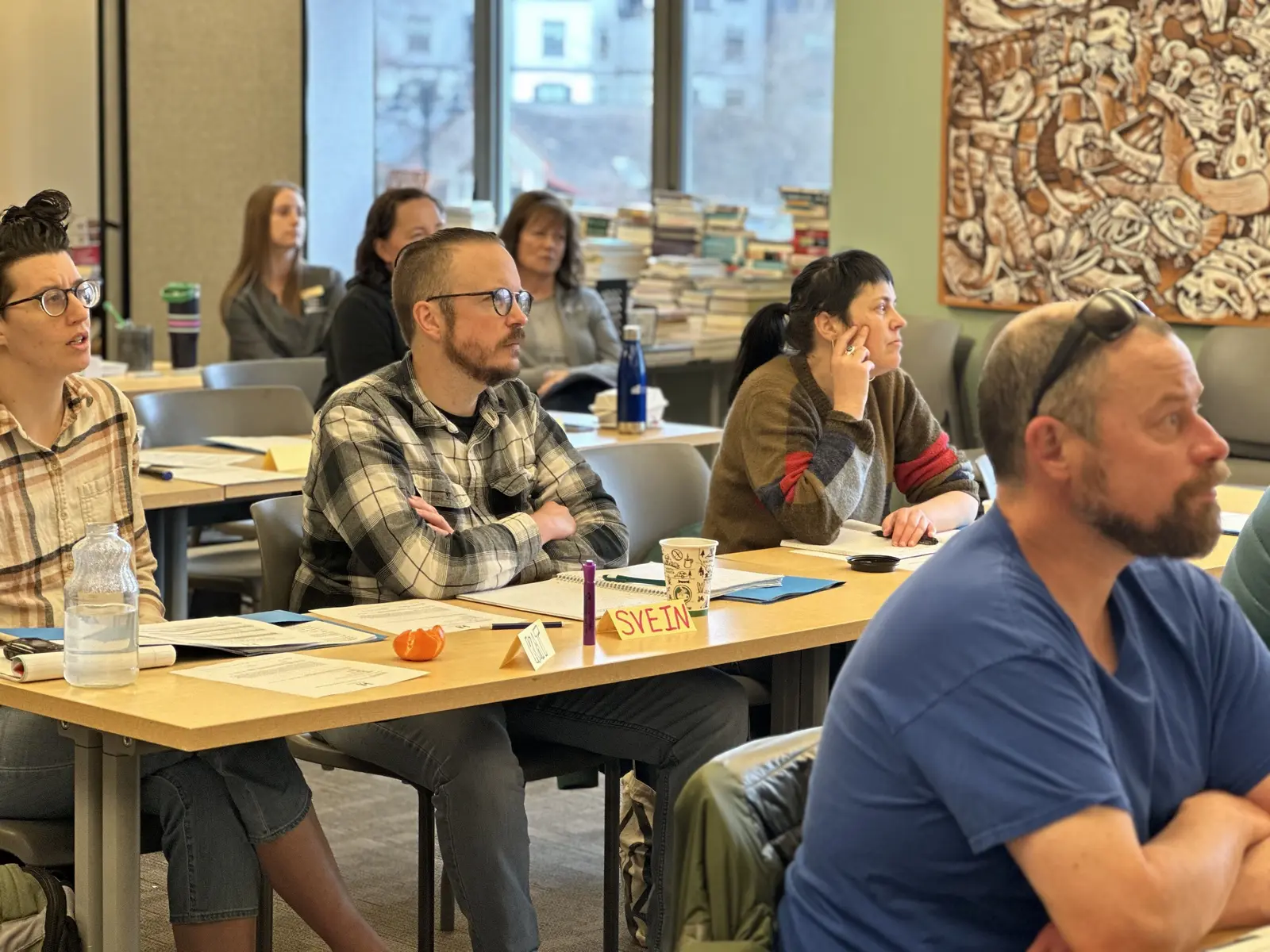 A group of adults attending a workshop or meeting in a room.