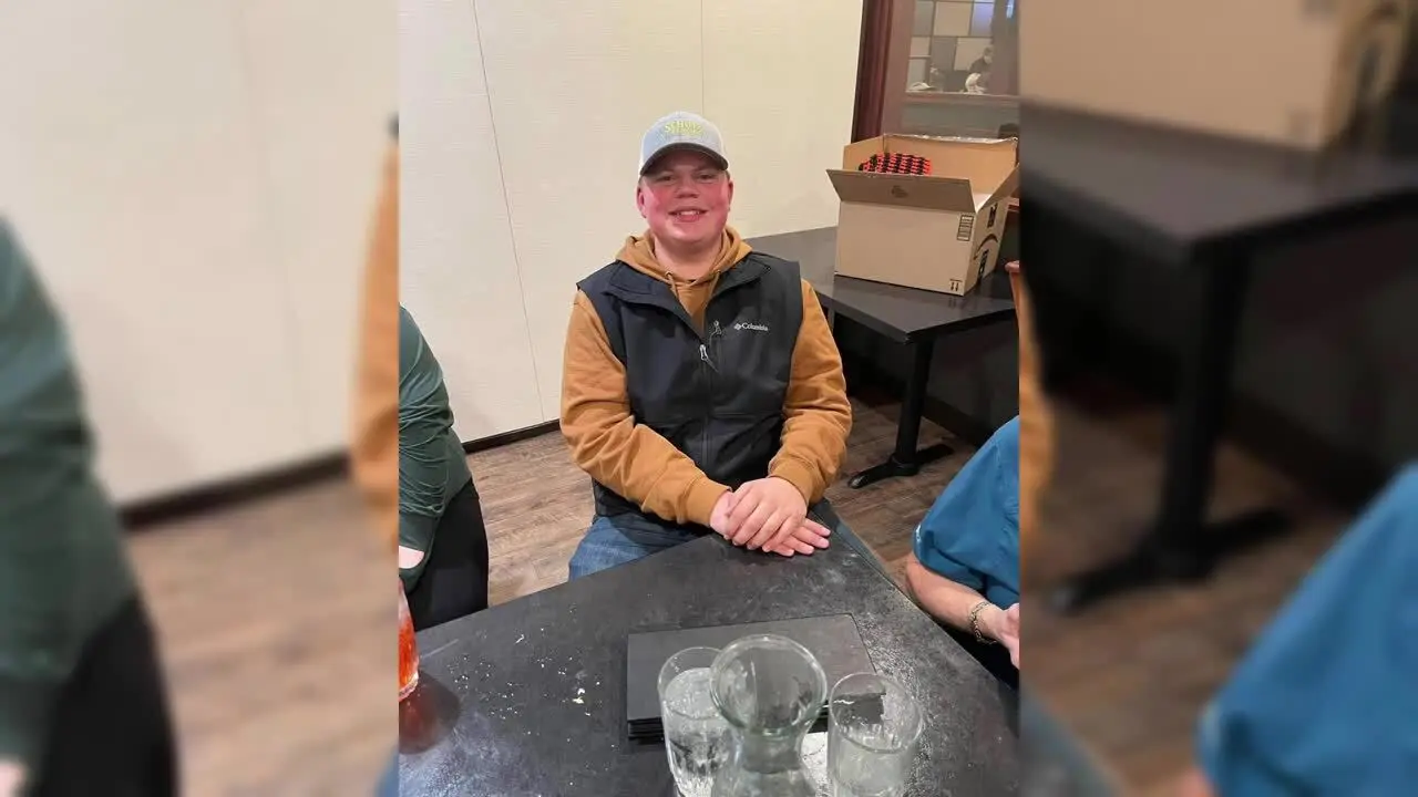 A young man sits at a table.