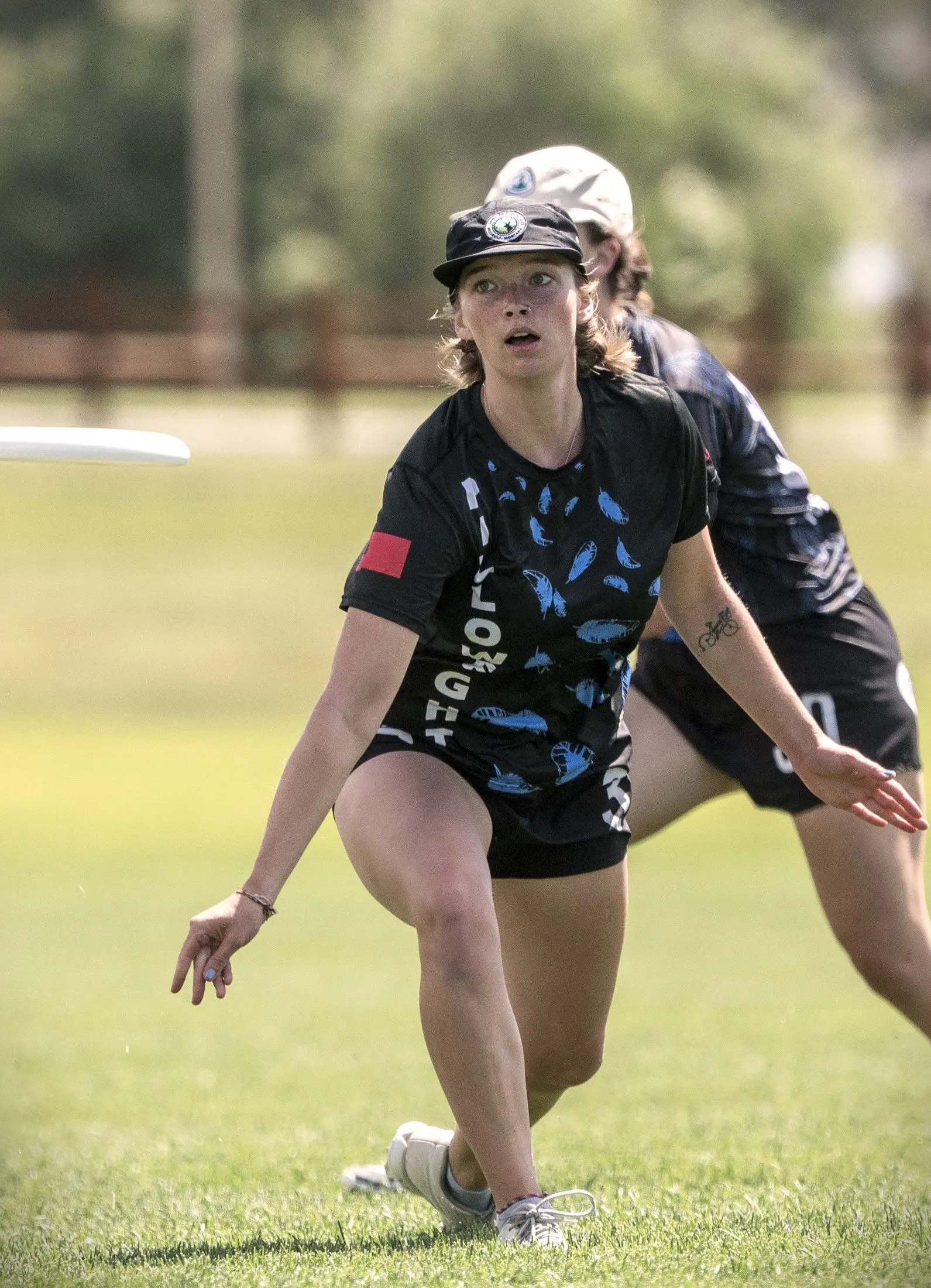 A young woman playing ultimate frisbee on a field.