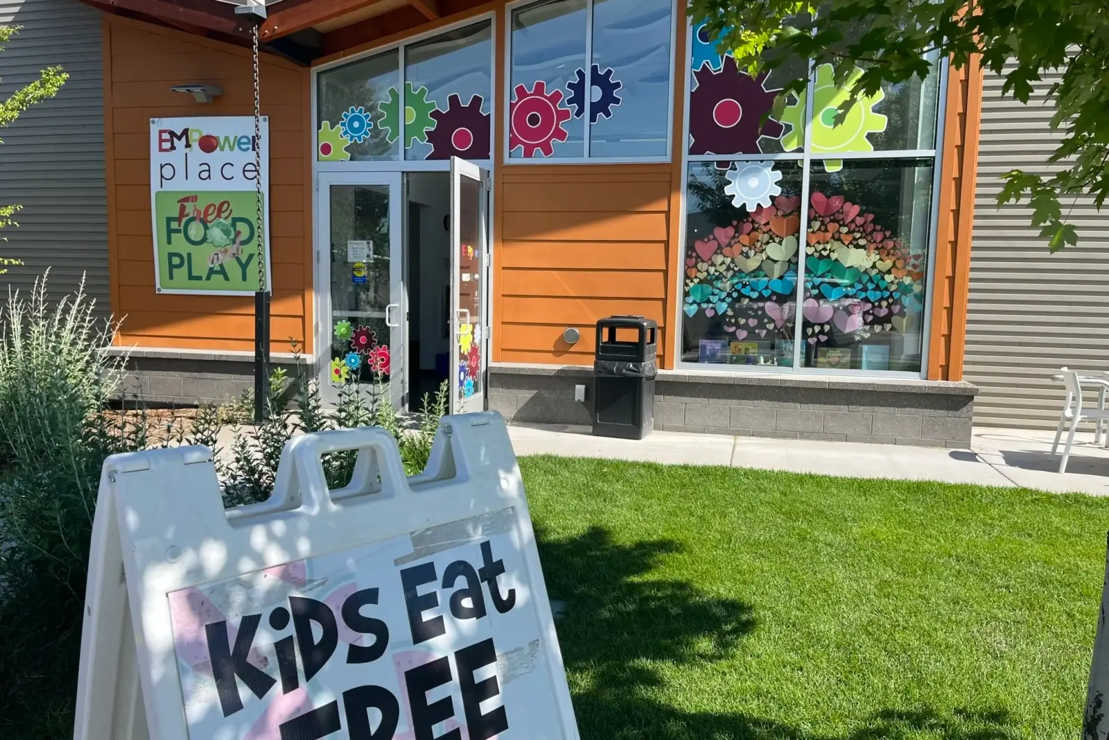 The exterior of a building features a sign promoting free food for kids.